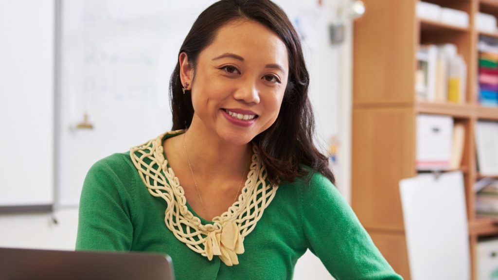 A person smiling while sitting in front of their computer