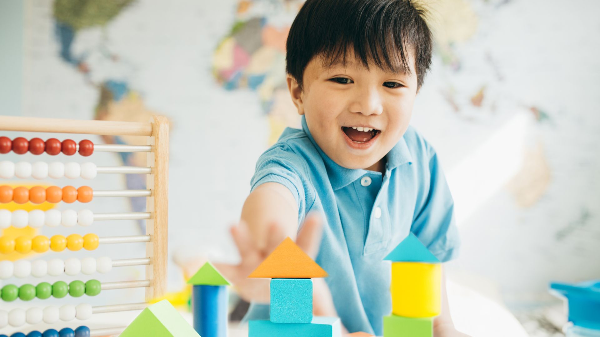 An image of a young boy reaching for colorful blocks.
