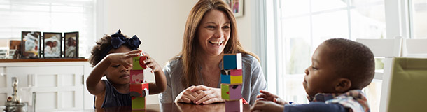 Provider with two children playing with blocks on a table