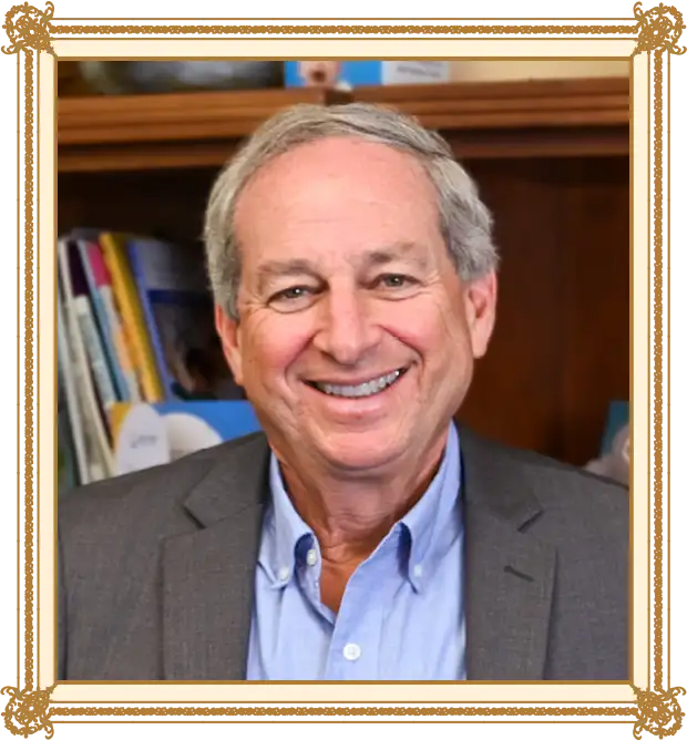 Honoree Dr. Michael Olenick in front of a book shelf smiling