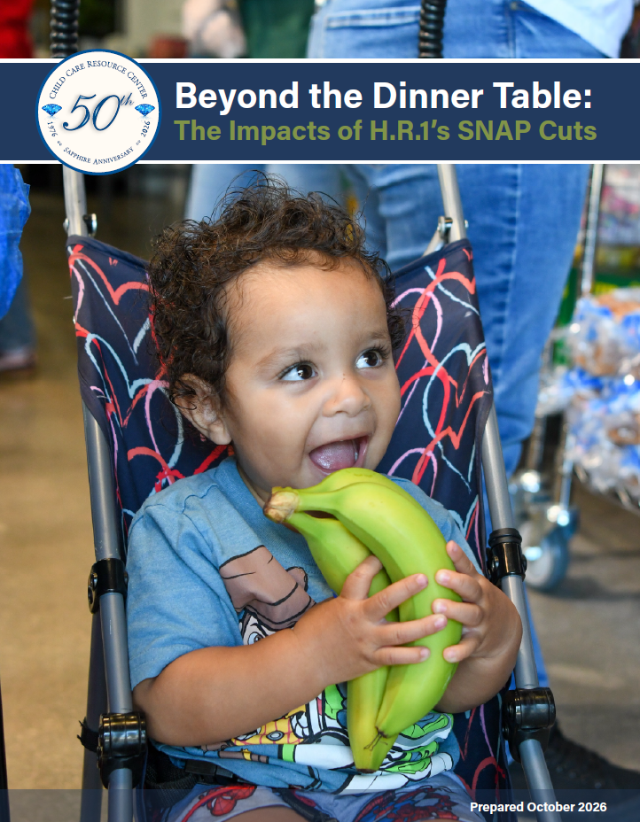 Child in a stroller smiling and holding bananas.